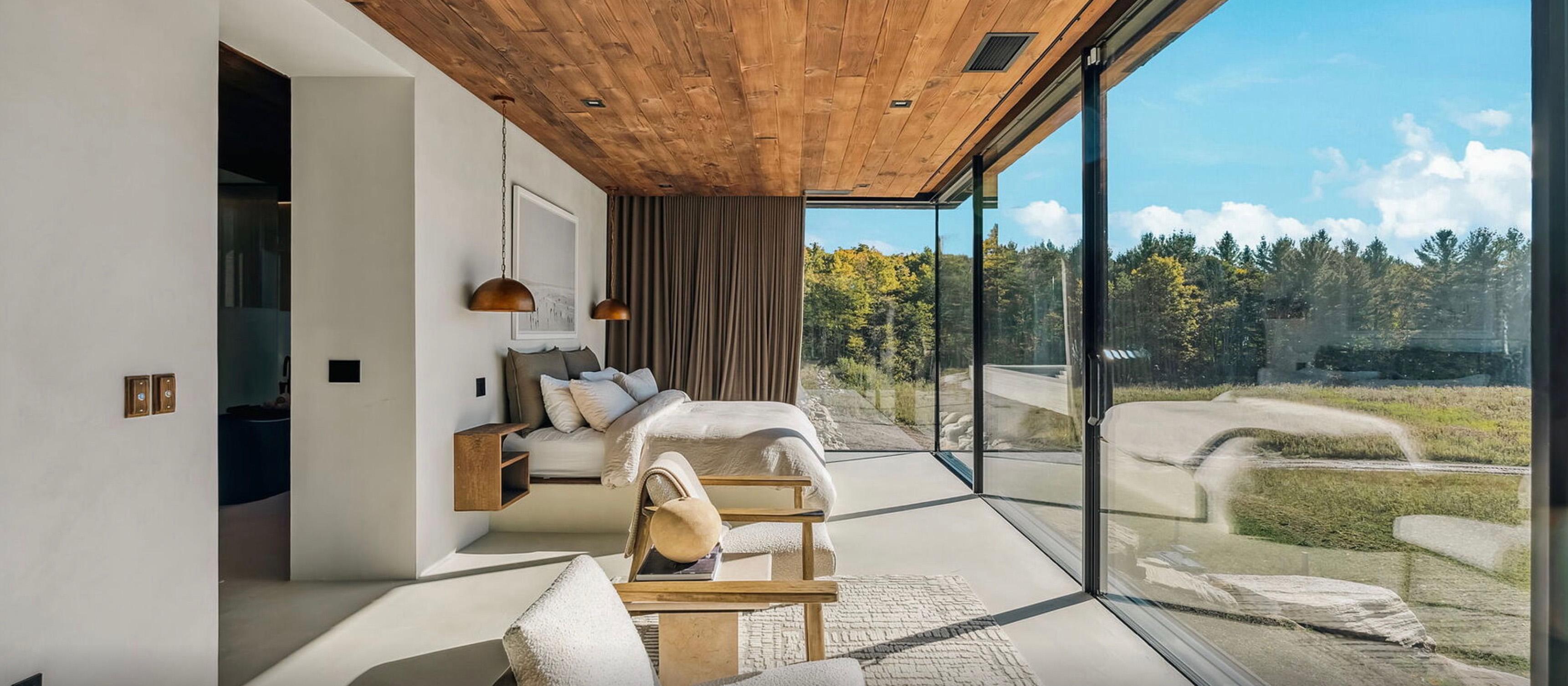 Floor-to-ceiling glass framing the woodland